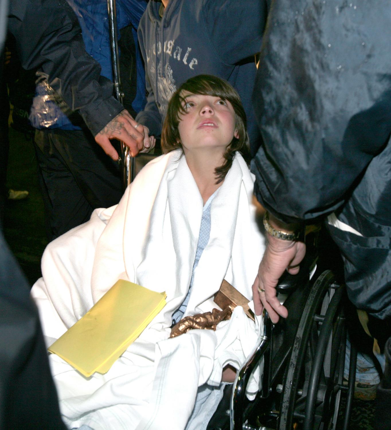 Joshua Dominguez, 12, gets wheeled passed reporters after being discharged from Feather River Hospital in Paradise, Calif., on Wednesday, Dec. 19. Joshua, two siblings and his father were rescued after a snow storm hit while they were looking for a Christmas tree.