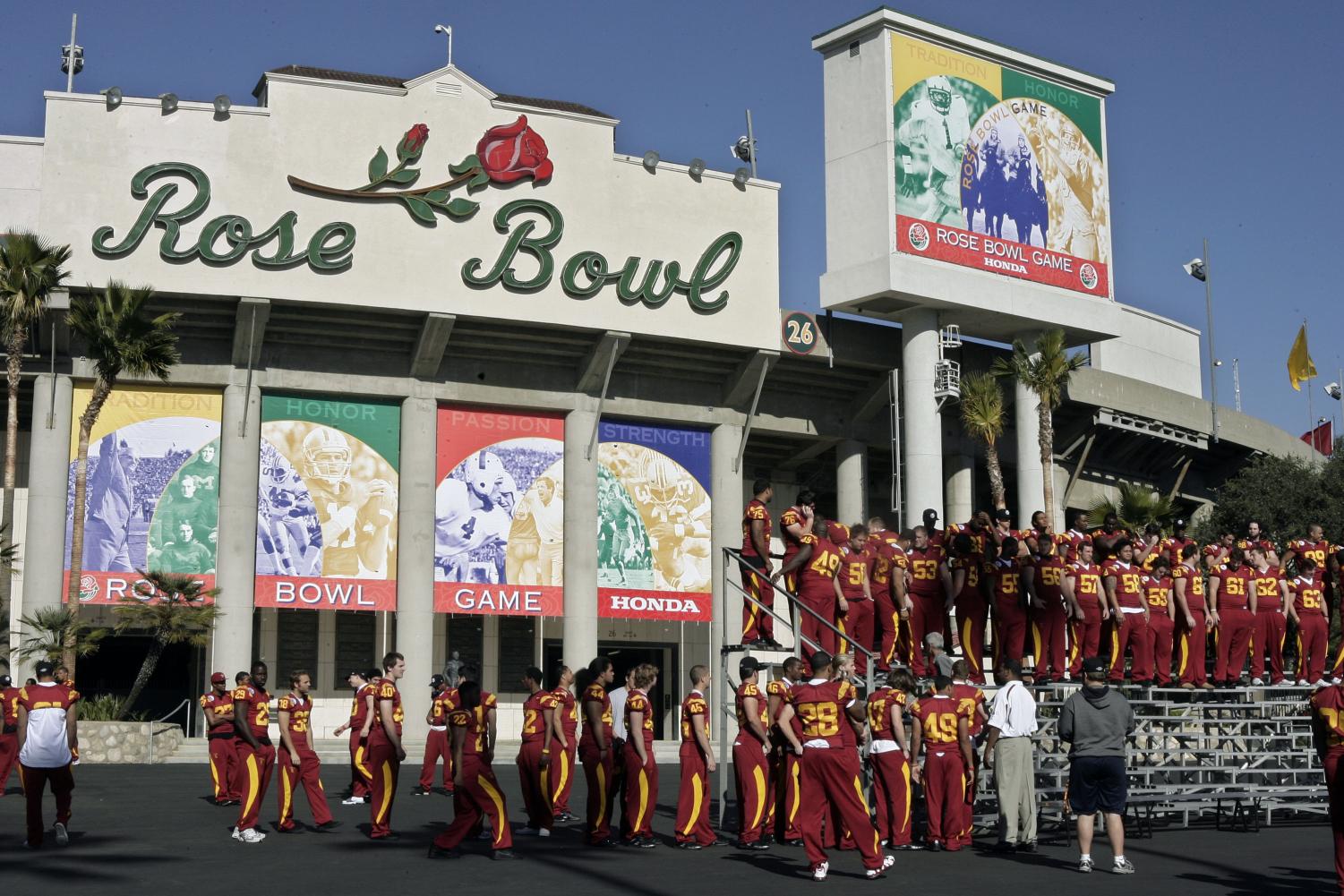 While revelers prepare to ring the new year in Times Square, Pasadena prepares for the Rose Bowl and Rose Parade. Southern California football players take their places for a team photograph Monday, in Pasadena, Calif. USC will play Illinois in the Rose Bowl football game on New Year's Day. (AP Photo)