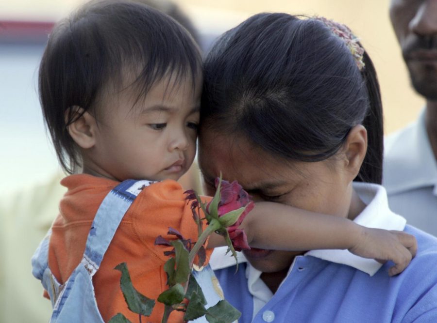 A young Thai mother and son attend a memorial service in Khao Lak, Thailand, Wednesday, Dec. 26, 2007, on the third anniversary of the Asian tsunami. More than 8,000 people in Thailand were killed when the tsunami wave struck the area following massive earthquake. (AP Photo)