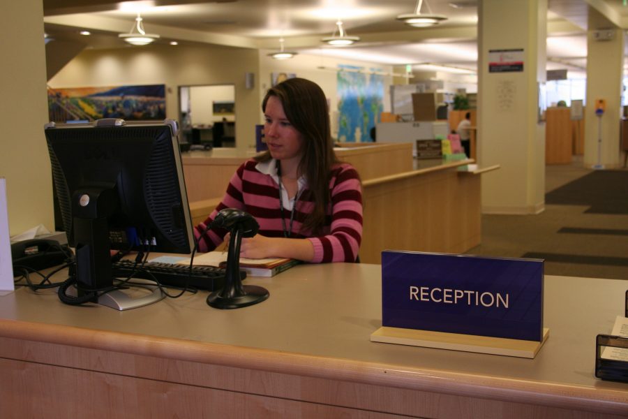 At the Biola Library, sophomore Julie Baker sits at the Reception Desk in order to supervise the incoming traffic.   Photo by Kelsey Heng