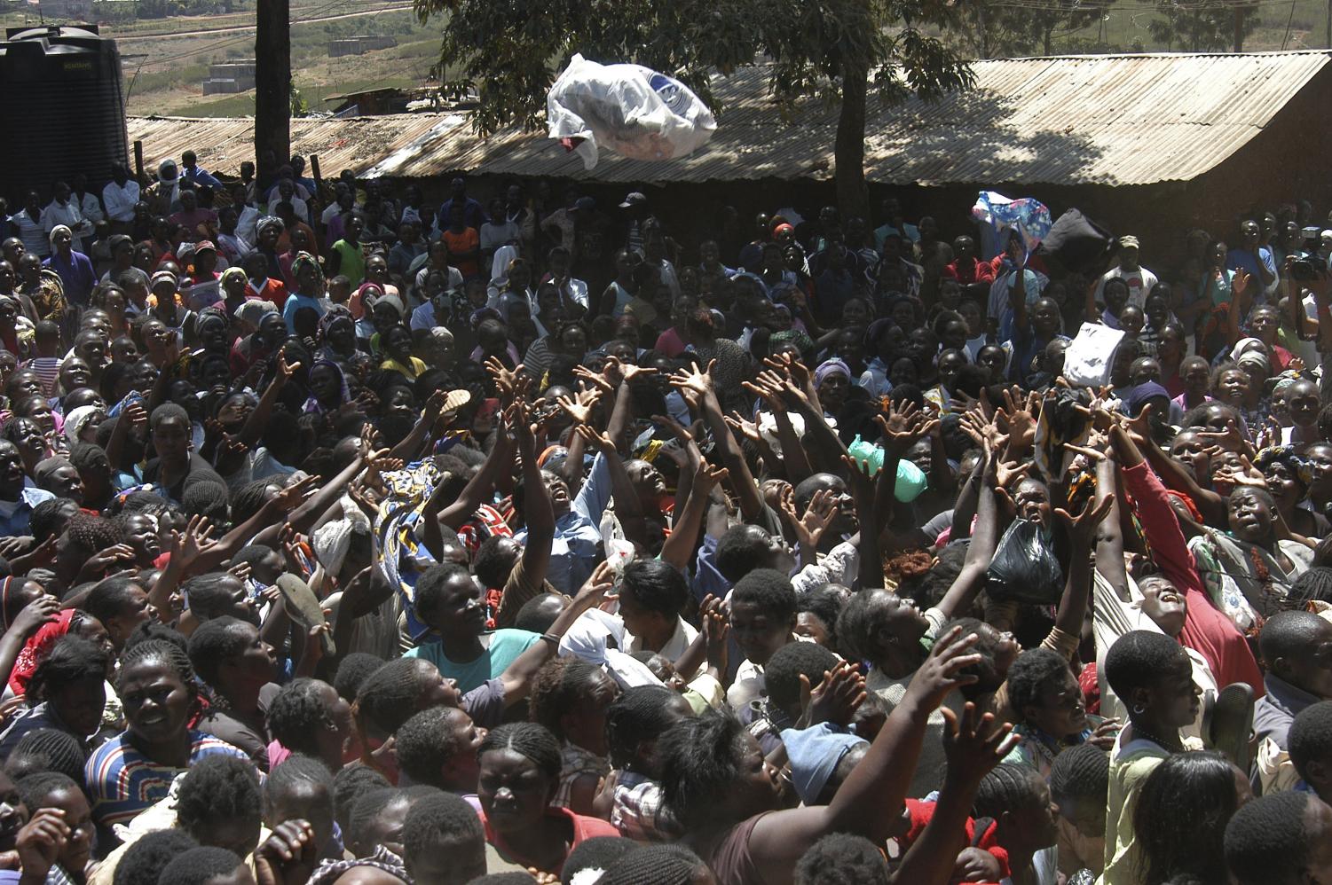 Kenyans reach out to grab clothes handed out by the Kenyan Red Cross, Tuesday, Jan.8, 2008 in the Kibera slum in Nairobi. Kenya's president and his chief rival made key concessions to end the dispute over the country's elections, calling off protests and agreeing to talks under pressure from the United States as the death toll from a week of violence reached nearly 500.