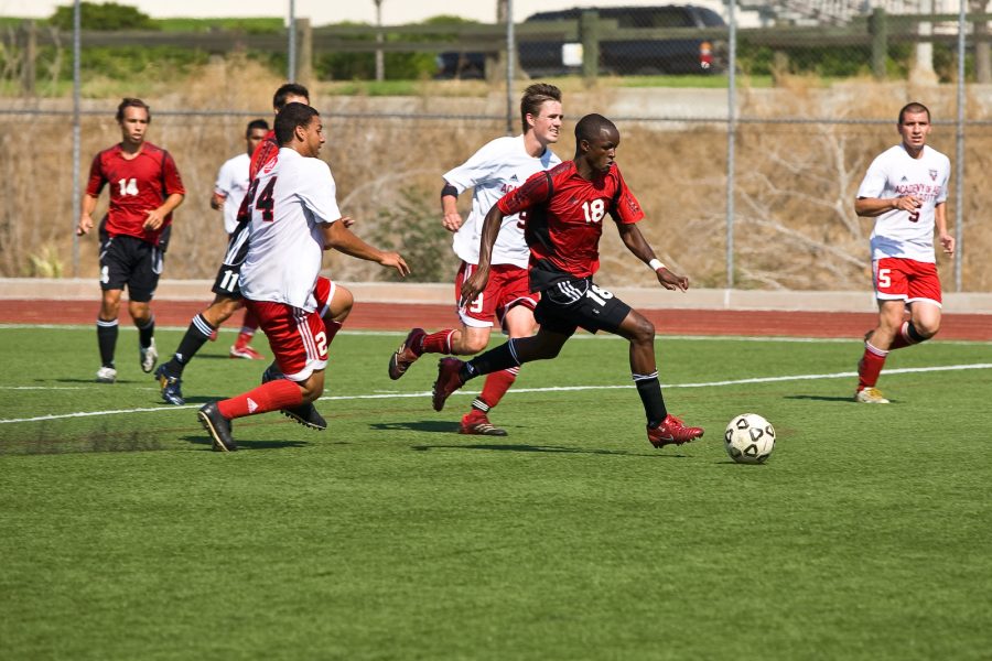 Kennedy Chongo, a sophomore, speeds past two defenders before scoring a goal. Photo by Mike Villa