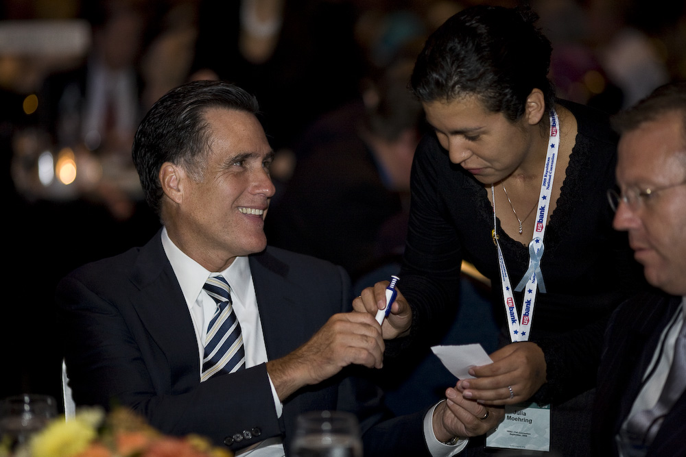 Former Mass. Gov. Mitt Romney signs an autograph Saturday at the California Republican Party convention in Anaheim. Romney's talk focused on making the U.S. more competitive in the world economy.  Photo by Mike Villa