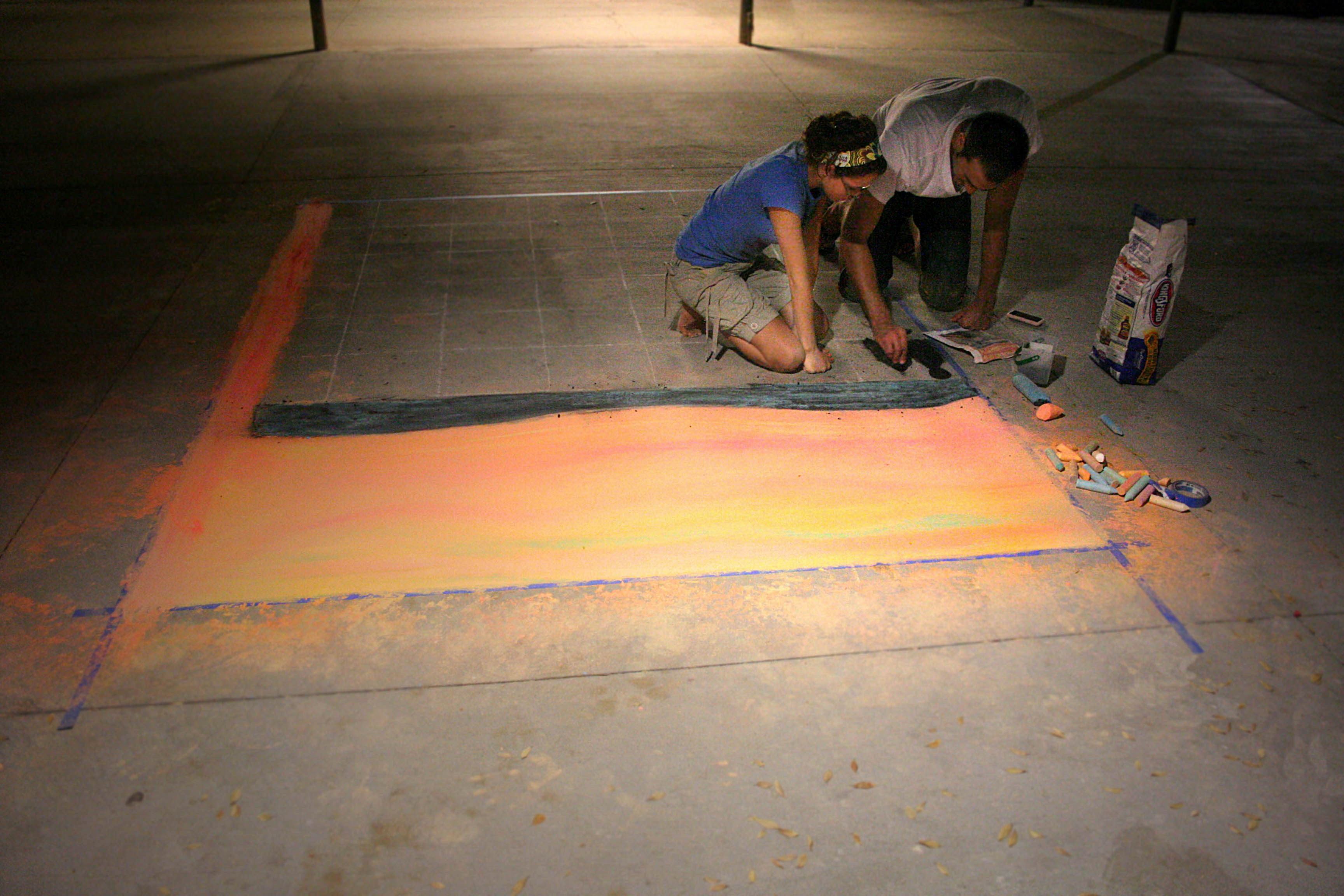 Patricia Petrusan and Dennis Darabant worked outside of the production center Wednesday night with chalk recreating the Edvard Munch's Scream for a 4-D art project.   Photo by Kelsey Heng