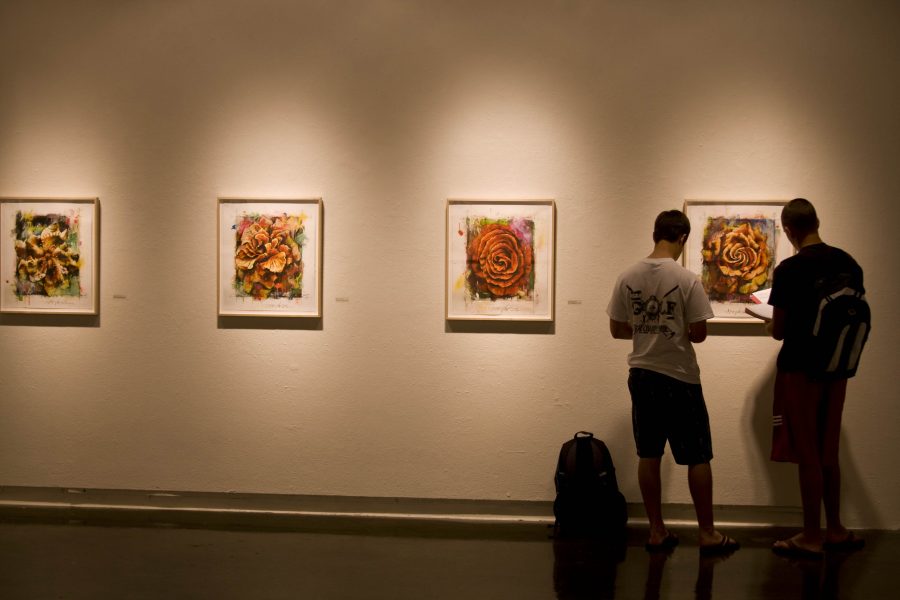 Freshmen Sam Howell and Andrew Johansson study the work of Los Angeles artist Jim Morphesis whose show, Anastatis, features his collection of portraits of the human figure using pieces of meat. Photo by Bethany Cissel