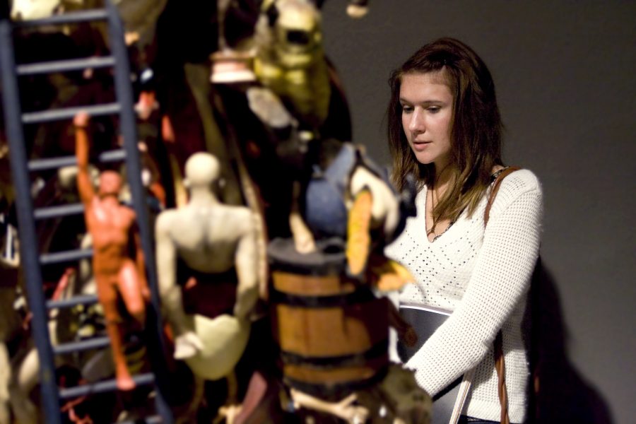 Senior Alison Hohler admires one of Barry Krammes assemblage pieces at the opening reception of Morality Tuesday, Jan. 27.  Photo by Kelsey Heng