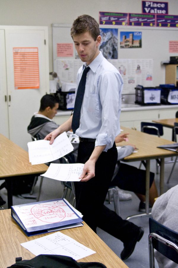 Jeremy Mann, teacher with the Teach for America program, passes out a class assignment for his middle school math class in the morning of Wednesday, March 4.  Photo by Kelsey Heng