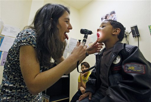 Pediatrician and primary physician Dr. Ellen Rothman, left, gives Makhi Hatch, 4, an examination for his cough as his mother Stephanie Correa, center, watches on, at the St. Johns Well Child and Family Center in Los Angeles Wednesday, April 29,. The St. Johns Well Child & Family Center, which oversees clinics that treat Los Angeles poor and uninsured, doctors have seen a surge in patients complaining about flu-like symptoms. (AP Photo/Damian Dovarganes)