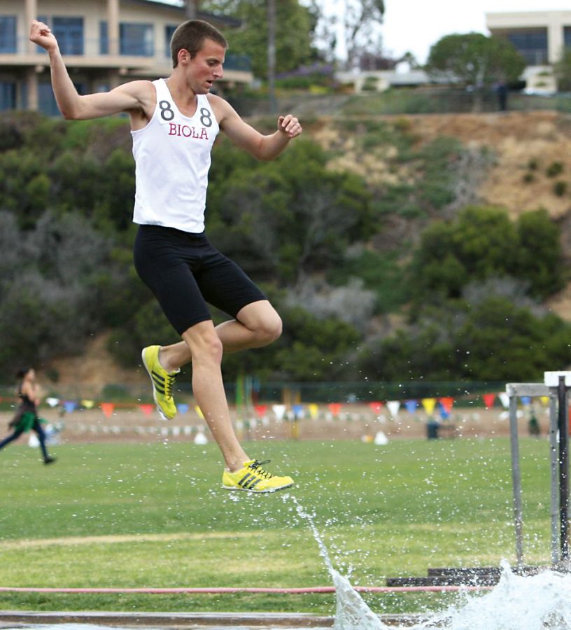 Junior Kyle McNulty flies over a steeple during the steeplechase track event at Point Loma on Saturday, April 25. Nine participants from Biola will move on to Nationals. 