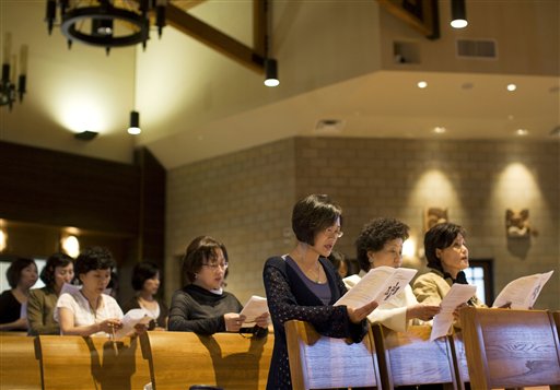 In this photo taken Monday, Aug. 10, members of the St. Thomas Korean Catholic Center pray in their newly built church in Anaheim, Calif. The congregation is one of the largest Korean Catholic churches in the country. St. Thomas Korean Catholic Center of Anaheim and other Korean Catholic centers have seen their pews fill up in recent years, aided by a surge in immigration to affluent Orange County and a steady stream of converts who come to the faith after settling. (AP Photo/Philip Scott Andrews)