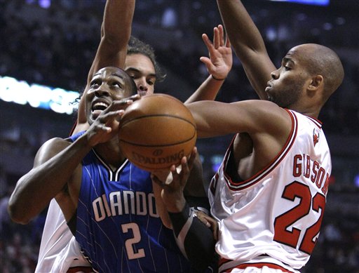 Orlando Magic guard Dwight Howard splits the defense of Chicago Bulls center Joakim Noah, background, and forward Taj Gibson (22) during the first quarter of their preseason NBA basketball game Monday, Oct. 19 in Chicago. (AP Photo/Charles Rex Arbogast)