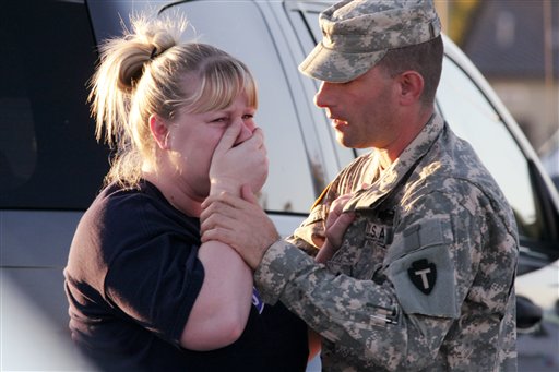 Sgt. Anthony Sills, right, comforts his wife as they wait outside the Fort Hood Army Base near Killeen, Texas on Thursday, Nov. 5. The Sills 3-year old son is still in daycare on the base, which is in lock-down following a mass shooting earlier in the day. (AP Photo/Jack Plunkett)