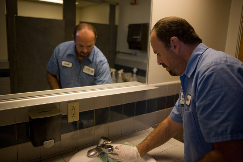 David Murphy cleans a bathroom in Stewart Hall. President Corey alerted employees last week that minimal, recession-related cutbacks may be made to campus employees next year.