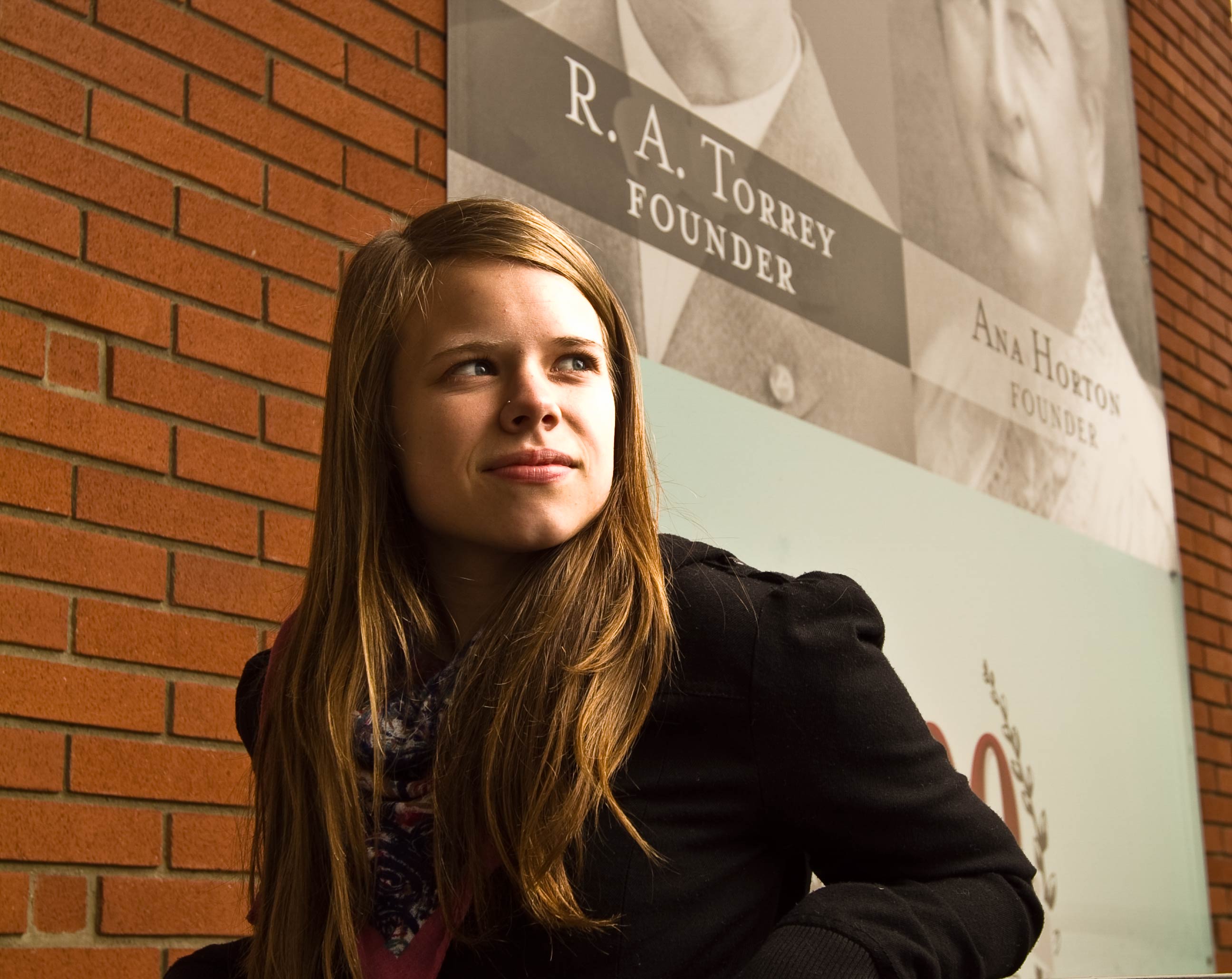 Joanna Torrey peers at the large poster draped over Horton Hall that displays Biola's founders and presidents. She is the great-great-granddaughter of R.A. Torrey, the first dean and a founder of Biola.