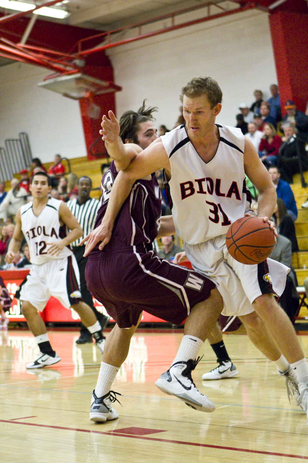 Senior Josh Miller drives around his defender along the baseline against Westmont College. The Eagles won 65-46 last week in Chase Gymnasium. JOB ANG/The Chimes
