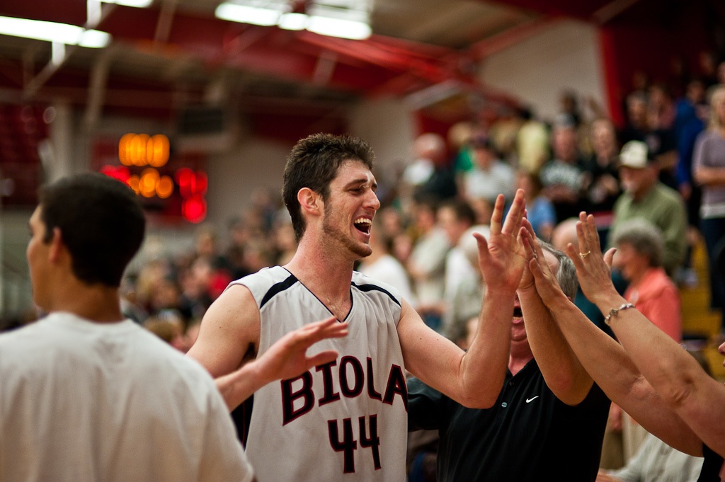 Senior Beacon Schroeder steps off the court to high-fives from fans after Biola beat previously undefeated Concordia 73-70 in the basketball game on Tuesday night. | Mike Villa/THE CHIMES