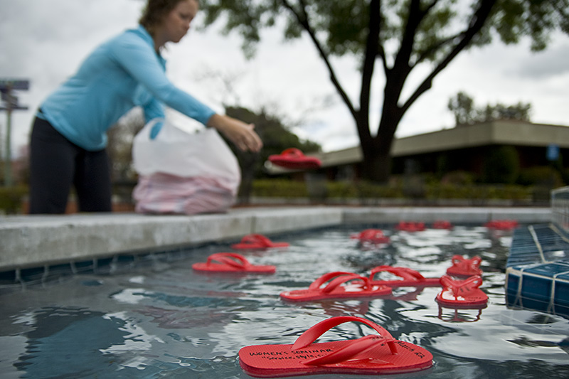 University Communications and Marketing intern junior Lydia Ness fills the Fluor Fountain with promotional flip-flops for this week’s women’s month events on campus. | Kelsey Heng/THE CHIMES
