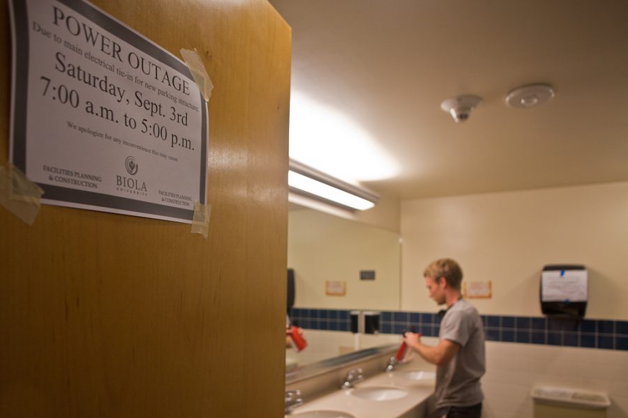 Senior facilities worker Nate Hocking places lights in the Hart bathrooms in anticipation of the scheduled  September 3, 2011 Stewart/Hart power outage. | Ashley Jones/THE CHIMES