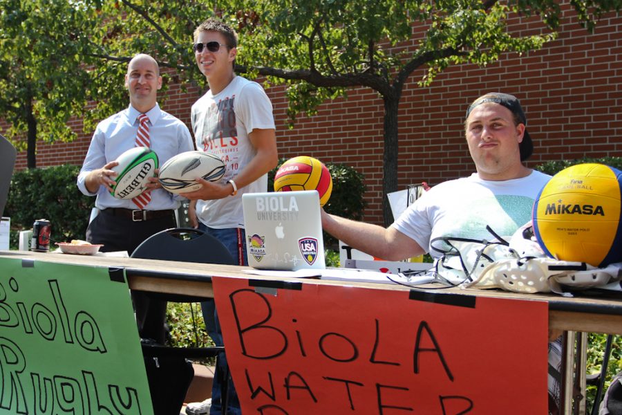 (L-R) Theology professor Andy Dracott, senior Anthony Cantu, and sophmore Josh Grossman run the Biola Rugby and Waterpolo tables on Wednesday, September 14, 2011.  | Tyler Otte/THE CHIMES