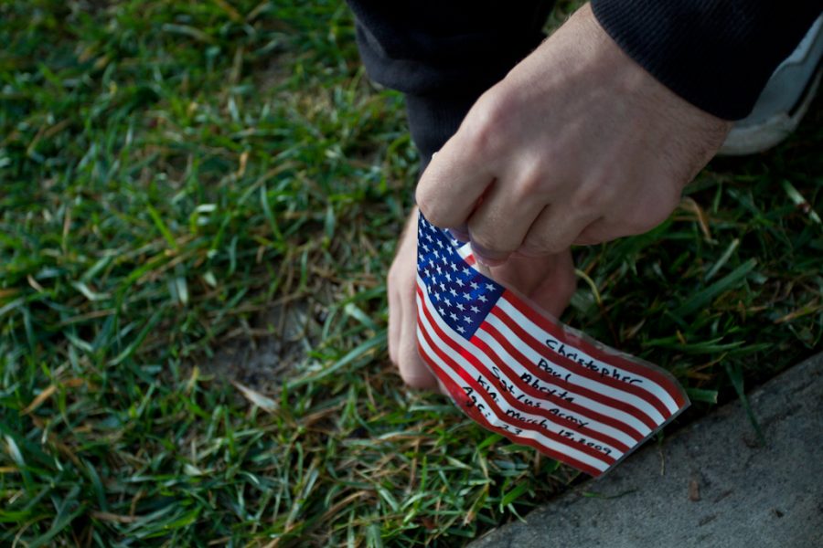 John Reid places flags in honor of the tenth anniversary of the beginning of the Afghanistan war on October 5, 2011. | Tyler Otte/THE CHIMES