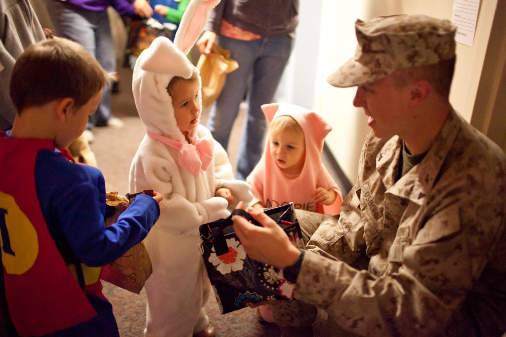 Sophomore, Cameron Osborn hands out candy to Isaac, Adella, and Elijah Hameson at Alpha's annual Candyland Event on October 31, 2011. | Ashley Jones/THE CHIMES