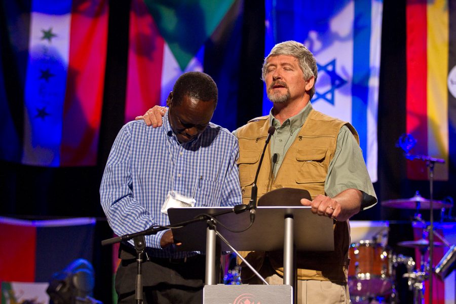 George Payton prays over the evenings speaker, Oscar Muriu before his message about our personal plans versus Gods. | Tyler Otte/THE CHIMES