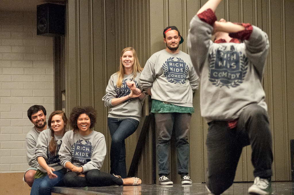 Team members looks on as junior Michael Mauriello participates in a scene in last Sundays show. Rich Kids Comedy Club performed their final show of the year on May 13 in Mayers Auditorium. The free show attracted a full audience. | David Wahlman/THE CHIMES