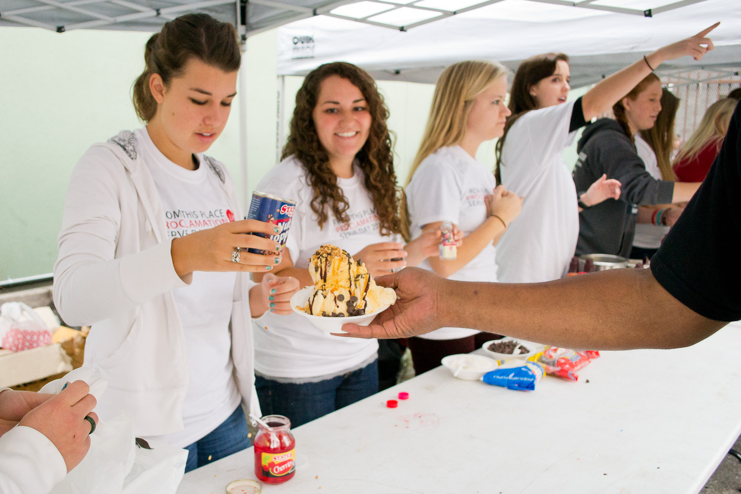 Junior Ann Teichert and senior Emily Ganzfried prepare an ice cream sundae for a Union Rescue Mission visitor. | Ashleigh Fox/THE CHIMES