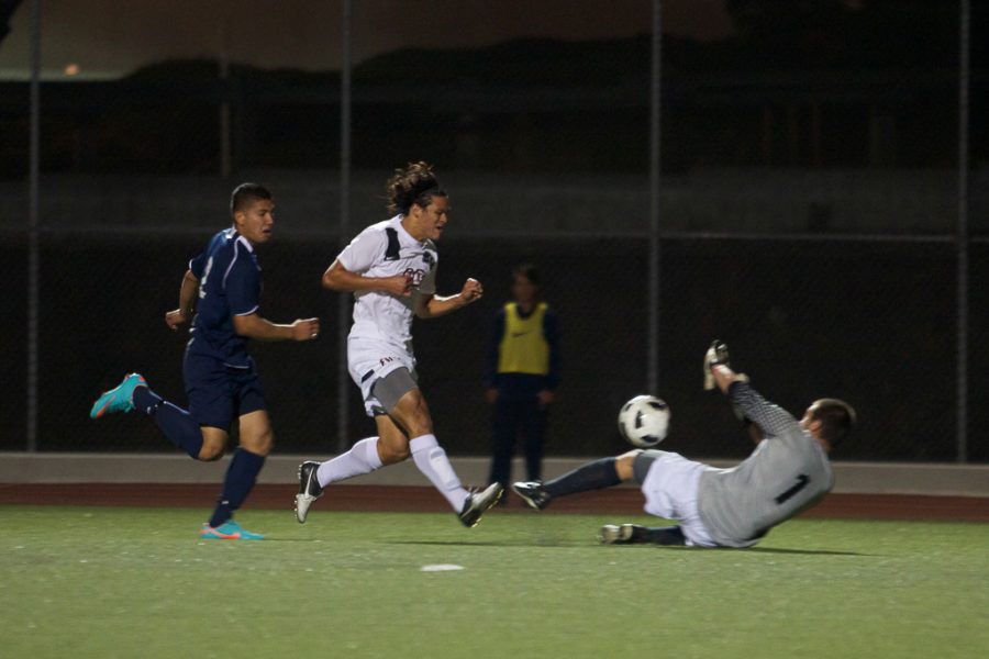 Junior Daniel Chew kicks the ball past the goalie to score a goal for Biola. | Ashleigh Fox/THE CHIMES