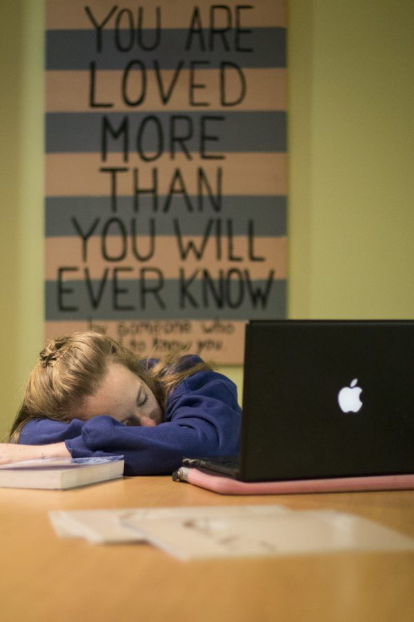 Photo illustration of exhausted sophomore Emily Conrow choosing to sleep instead of go to class. | Emily Arnold/THE CHIMES