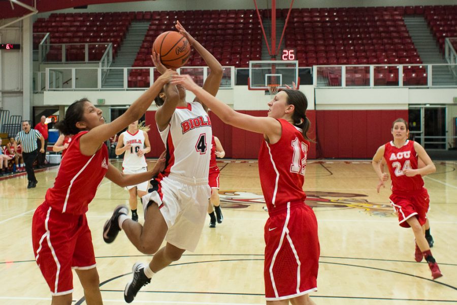 Sophomore Desiree Robinson attempts a shot while ACU aggressively defends the basket. | John Buchanan/THE CHIMES