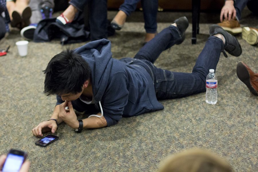 Waiting for senior Chris Yims phone call, junior Evan Tan lies on the floor of the upper lobby in Hart Hall. | John Buchanan/THE CHIMES