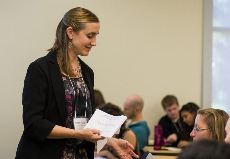 During her Saturday afternoon workshop, Sarah Visser, from Azusa Pacific University, hands out a flyer entitled A Proactive Approach to Community to help students discern how to put what they are learning into practice. | Emily Arnold/THE CHIMES 