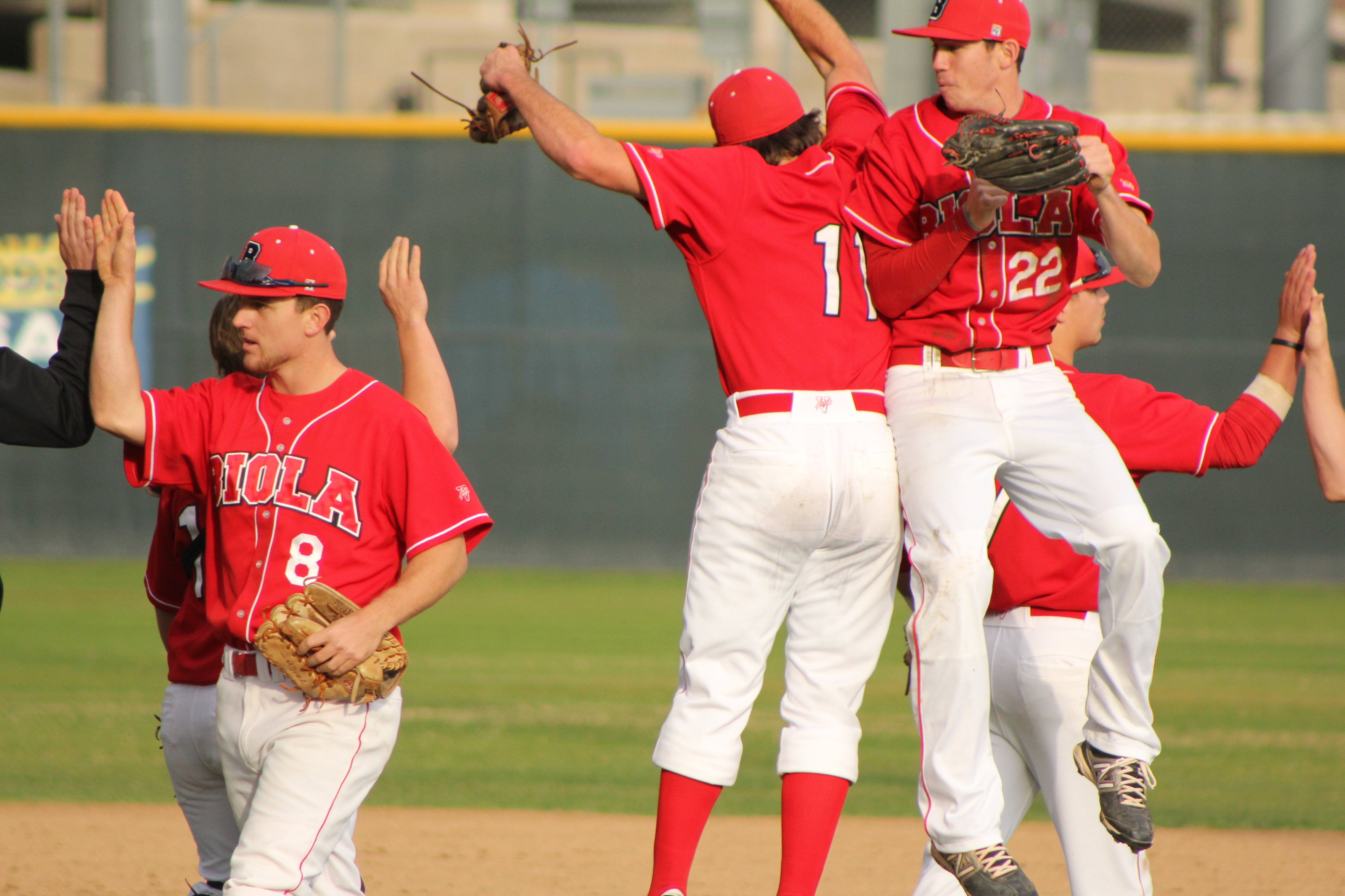 Senior starting pitcher Nick Turner (middle) celebrates with teammate Paul Slater (right) after Sunday’s 2-0 shutout of Arizona Christian. | Conner Penfold/THE CHIMES