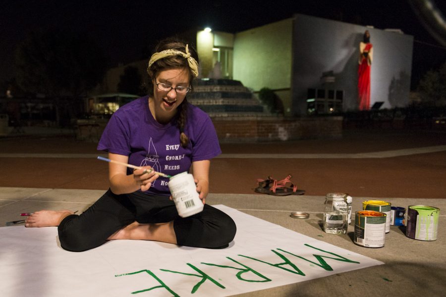 Sophomore Lisl Ruckert works diligently on a sign for the Marketplace located at Flour Fountain. Ruckert is one of hundreds of volunteers that worked through the night on Tuesday. | Ashleigh Fox/THE CHIMES
