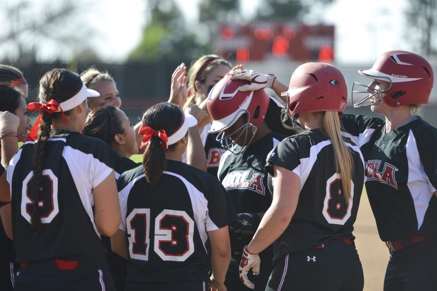  Fellow Eagles gather around senior Sam Roberts at home plate after her home run on March 21 vs. Hope International University. Softball made it all the way to the GSAC semifinals this year. | Olivia Blinn [file photo]