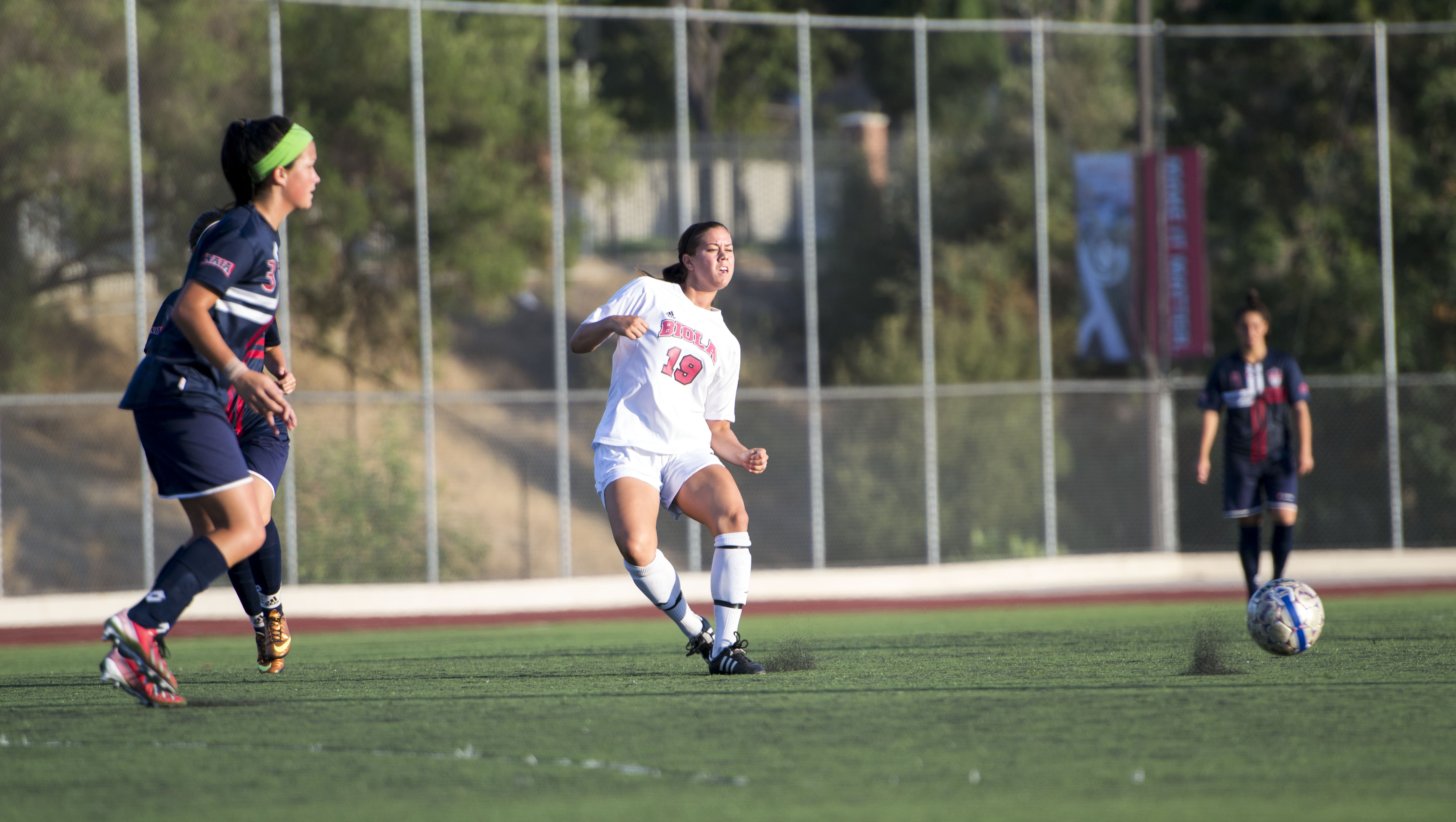 Senior midfielder Victoria Dalla Zanna passes to a fellow Biola teammate as the Oklahoma Wesleyan players inch closer. | Ashleigh Fox/THE CHIMES