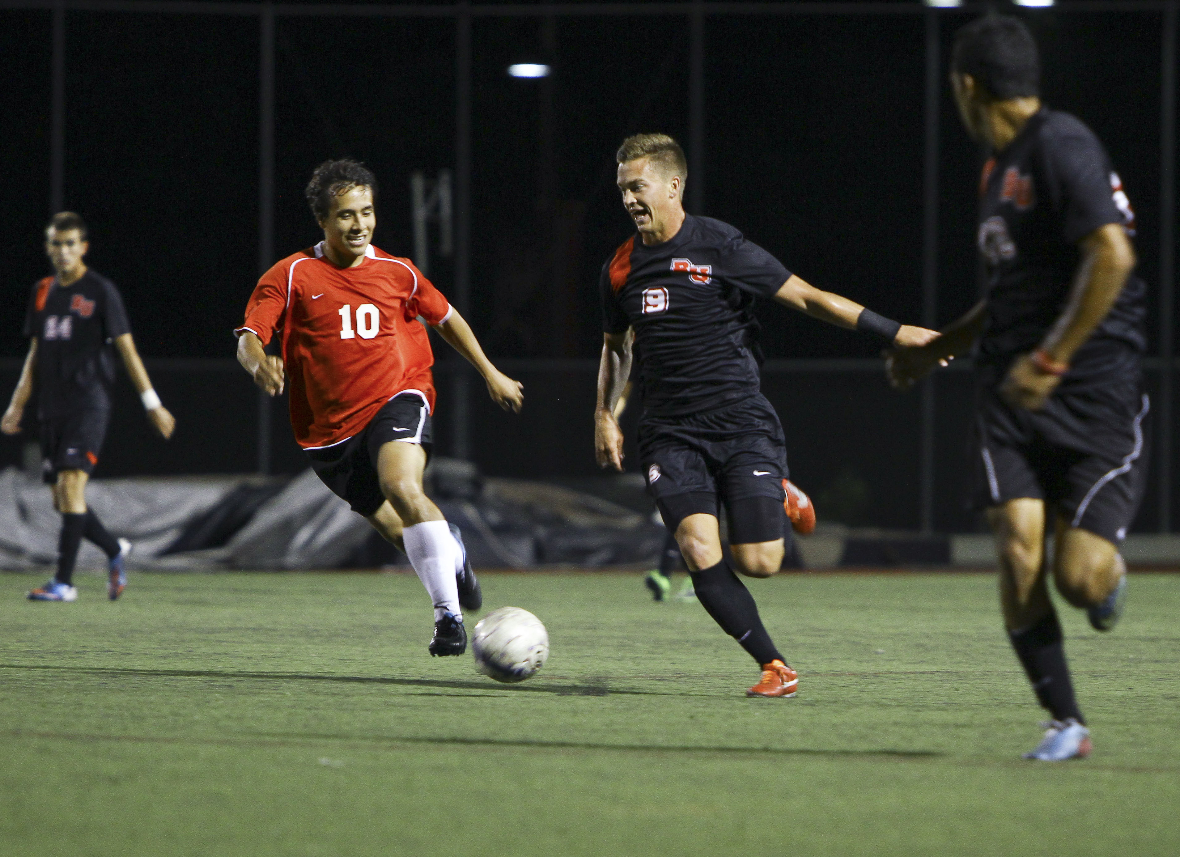 Sophomore Joey O'Keefe enjoys dribbling against a Biola alumni during the annual alumni soccer game. | Beth Crabtree/THE CHIMES