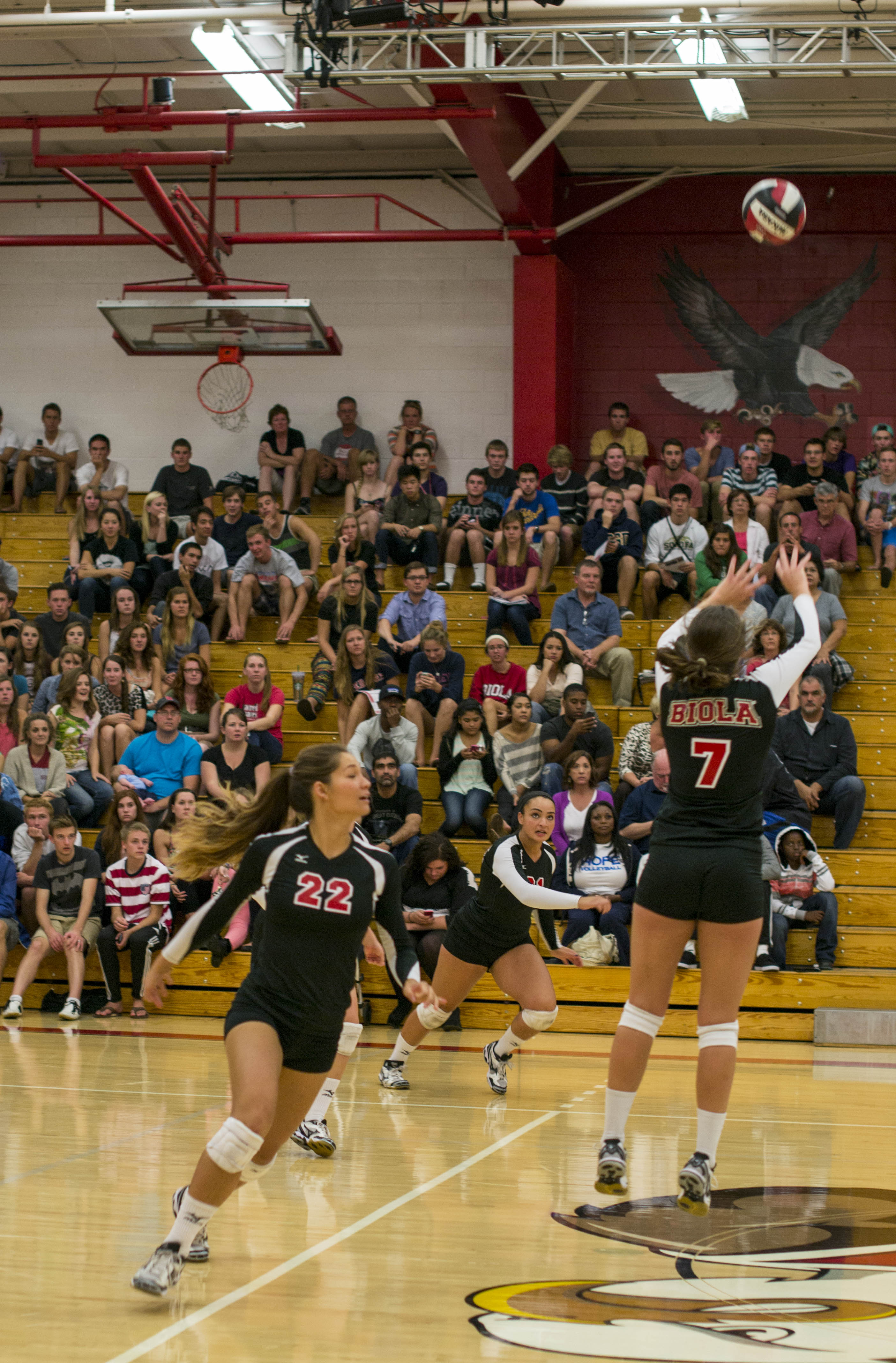 Sophomore #22 Lauren Hoenecke prepares for the fake as senior setter Nicolette Douglas sets up sophomore outside hitter Joclyn Kirton for the kill against Hope International. | Kalli Thommen/THE CHIMES