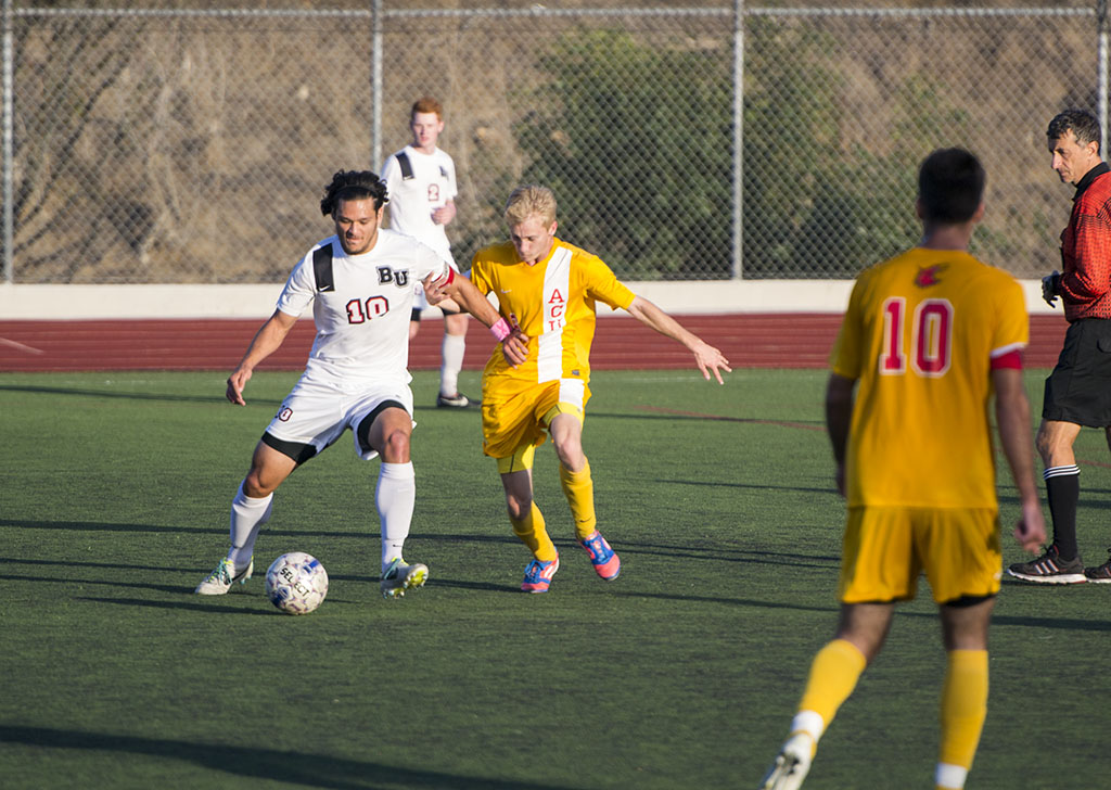 Senior Daniel Chew fends off the Arizona Christian defense during the game on October 29. Chew made his 14th goal of the season on his last home game of his Biola soccer career. | Kalli Thommen/THE CHIMES