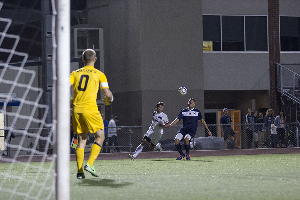 Senior forward Daniel Chew works against Masters defense to reach the goal. | Natalie Lockard/THE CHIMES