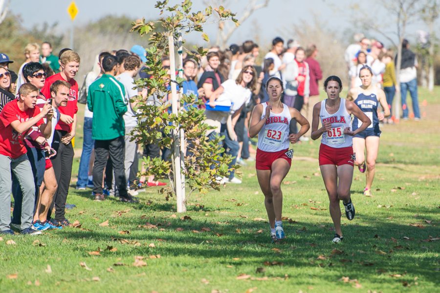 Junior Carrie Soholt and sophomore Kellian Hunt run side by side on the final stretch during the GSAC Championships in Costa Mesa. Hunt earned a first-place finish overall with a time of 17:27.15, followed closely by Soholt, who received second place with her time of 17:29.03. The women's cross country team will be competing at the NAIA National championship meet at 10:30 a.m. in Lawrence, Kansas on Nov. 23. | Ashleigh Fox/THE CHIMES