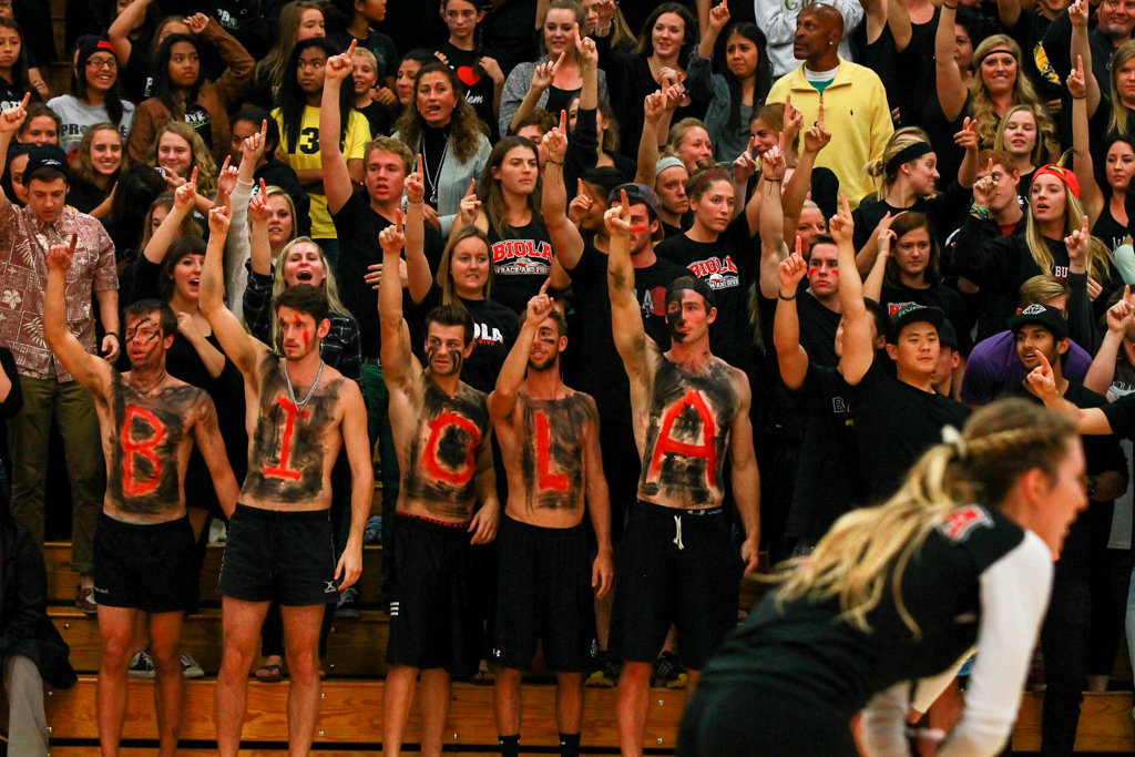 Deemed "Biola Blackout" night, a sea of black fans flooded the stands. Some fans, like the "B-I-O-L-A" men, led the crowd in cheering on the women's volleyball team. | Katie Evensen/THE CHIMES