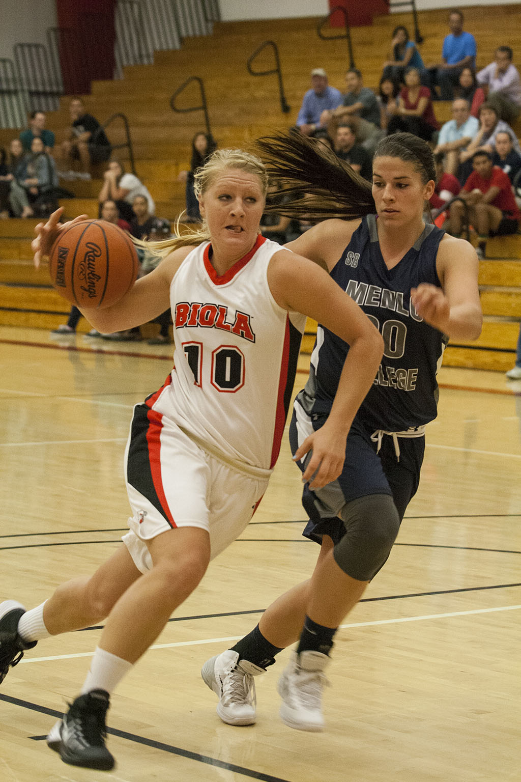 Menlo College's defense puts pressure on junior forward Elizabeth Munger during the game on November 9. The women's basketball team trailed Menlo by two points at the final buzzer, scoring 62 to their 64 points. | Elizabeth Kay/THE CHIMES