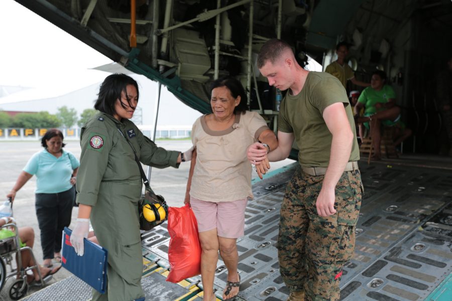 Lance Cpl. Alan Randall and a Philippine Air Force airman assist an injured Filipino woman off a KC-130J Super Hercules at Vilamore Air Base, Manila, Republic of the Philippines Nov. 11. The U.S. Marines are assisting the Philippine government with humanitarian aide and disaster relief in the wake of Super Typhoon Haiyan. | NASA/flickr.com [Creative Commons]