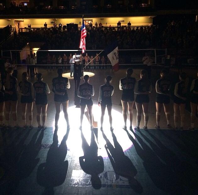 Lined up on the NAIA national championship court, Biola volleyball salutes the flag before their game against their Texas-Brownsville opponents. | Courtesy of Jaci Schork