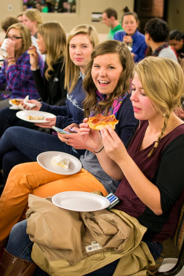 Freshmen Kelsey Nyce and Abby Conrad and sophomore Laura Bernard enjoy their pizza while waiting for the SMU Interterm trip presentations. | Kalli Thommen/THE CHIMES