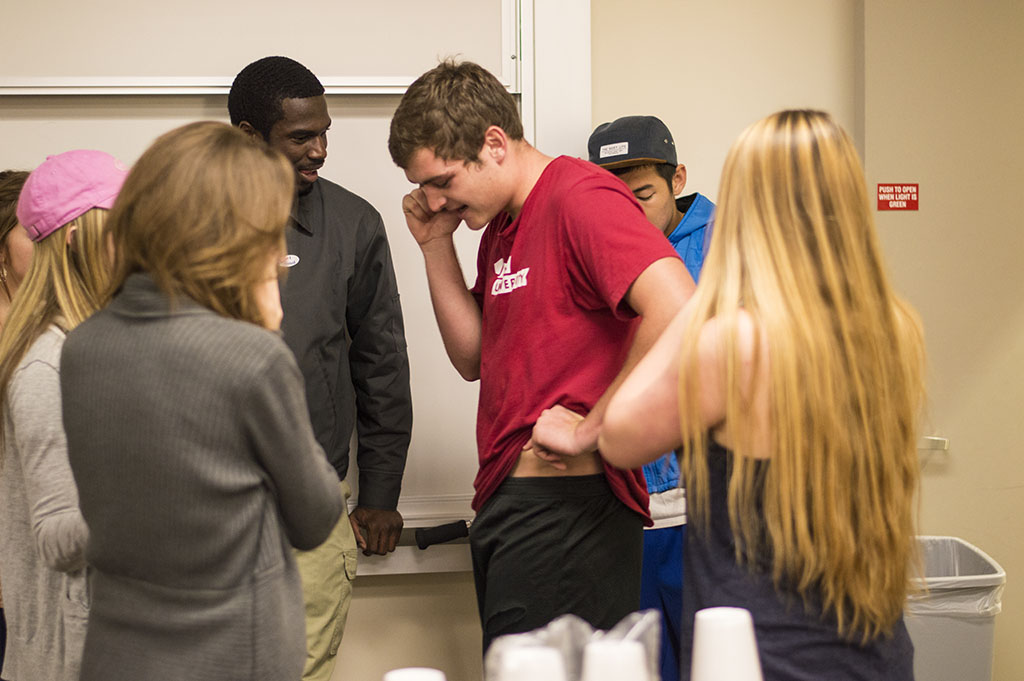 A group of friends surround SMU candidate Cody Storm, a sophomore international business major, while on the phone with current SMU president Roddy Garcia. Storm is the SMU president for the 2014-2015 school year. | Julia Henning/THE CHIMES