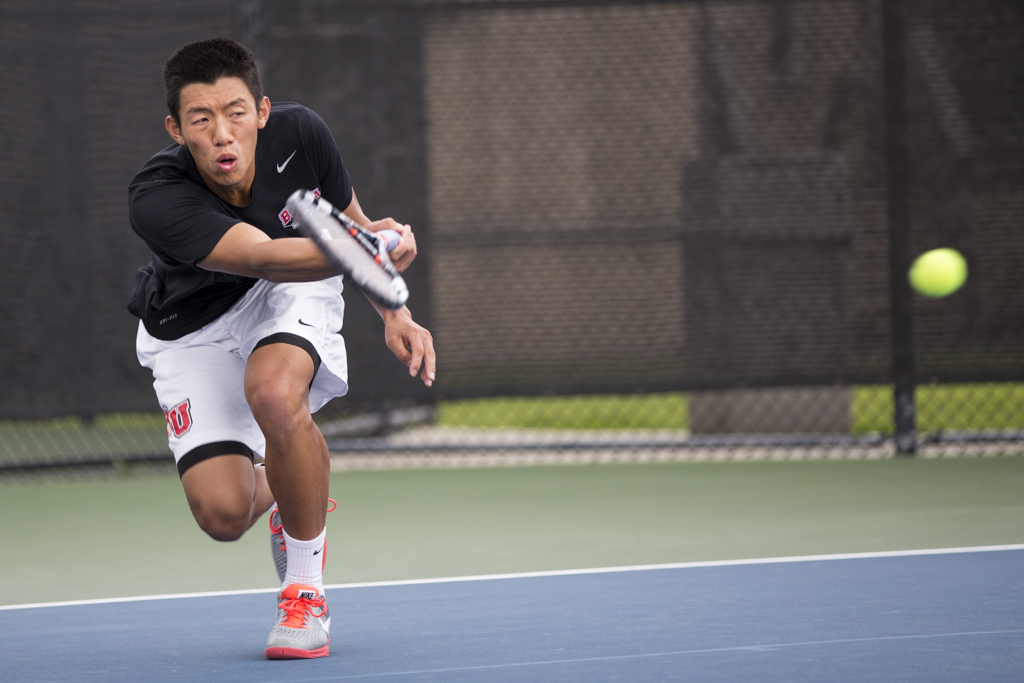 Junior Brandon Cheng pounds the ball over the net to his Hope International opponent. The mens tennis team collectively overpowered Hope International on March 25. | Amylia Lewis/THE CHIMES