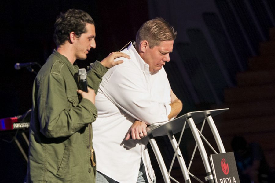 Co-director of Missions Conference Cody Nord ends the group prayer over Mickey Klink. It is Klinks last semester teaching at Biola, as he will be moving to northern Illinois to pastor a church there. | Kalli Thommen/THE CHIMES